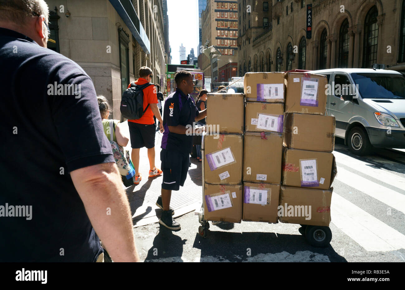 Una consegna Fedex uomo offre molte scatole di un edificio per uffici nel centro di Manhattan.New York City.USA Foto Stock