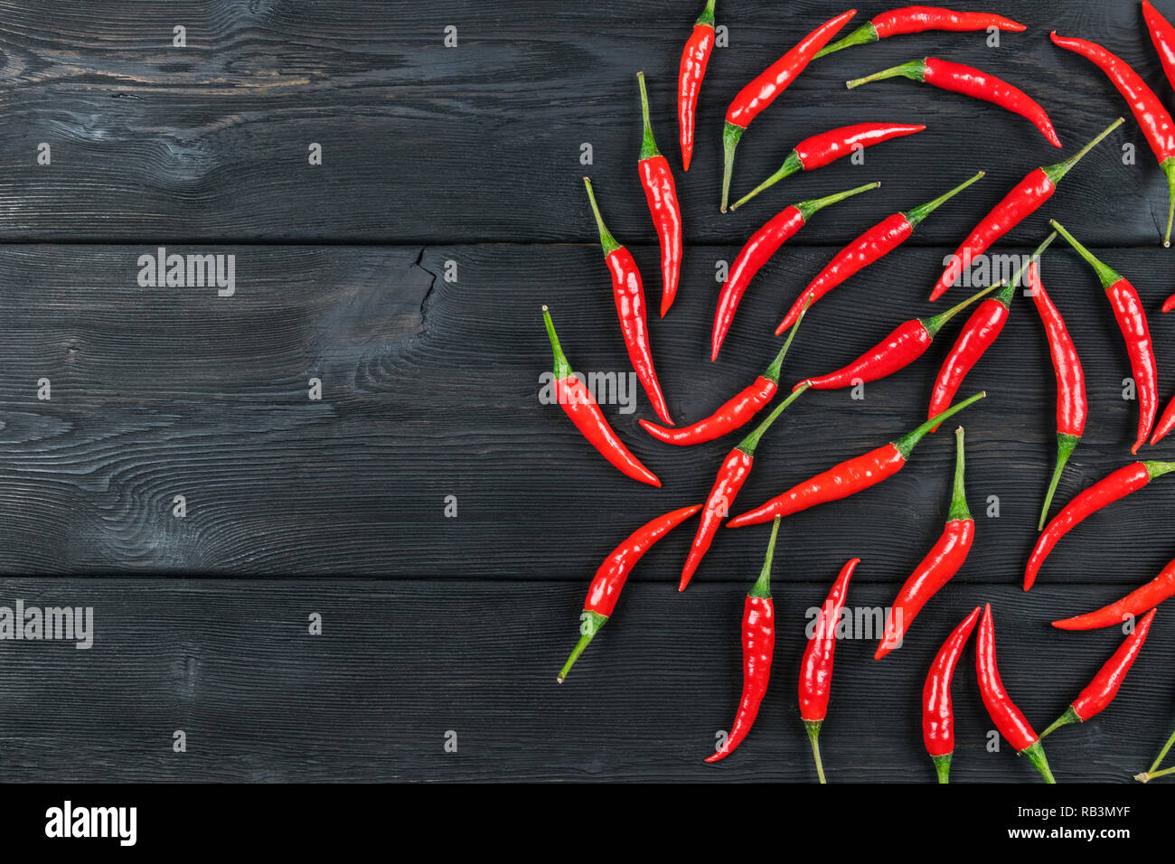 Peperoncino rosso sul legno scuro dello sfondo Foto Stock