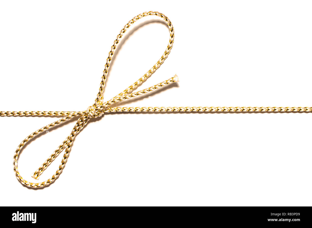 Golden satin corda parallela al telaio con annodato dono di prua di avvolgimento a nastro per il regalo di Natale con intricati dettagli shine isolato tagliato fuori vista superiore su Foto Stock