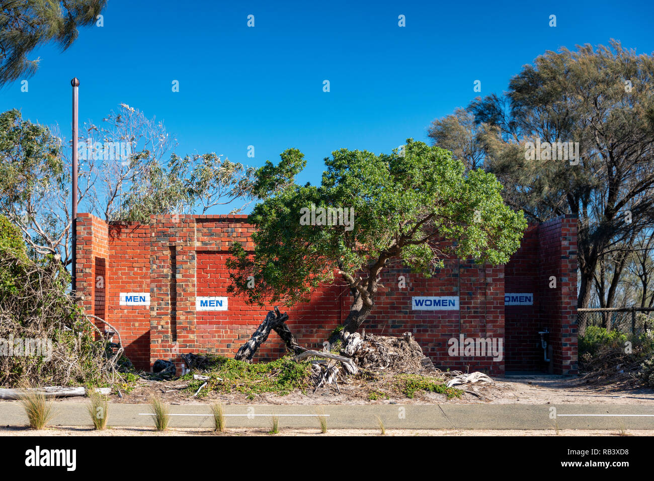 Un beachside blocco servizi igienici con gli uomini / Donne segni visibili, uomini al sole, donne in ombra Foto Stock