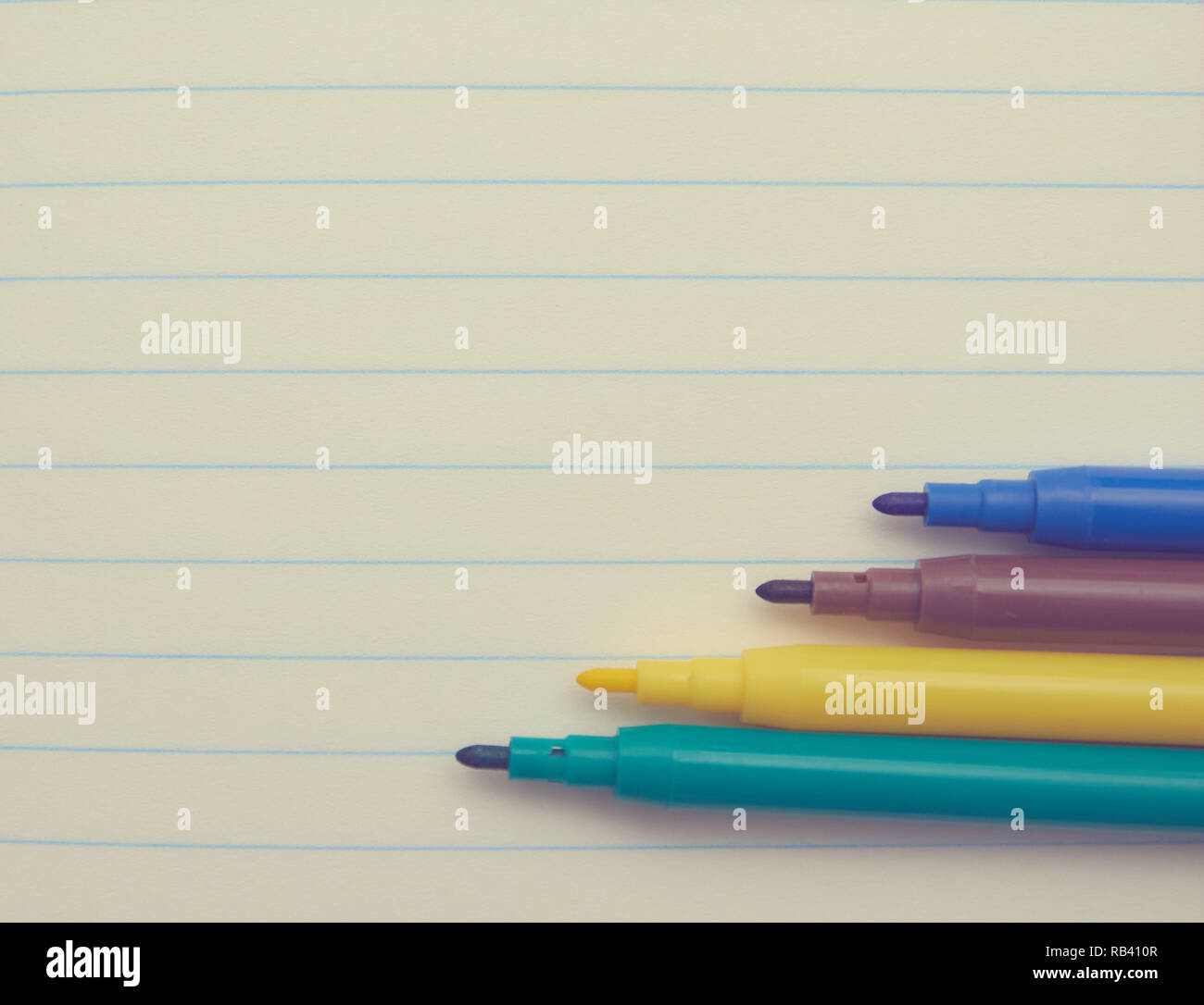 Quattro marcatori colorati su un bianco sullo sfondo del Blocco note, close-up, copia spazio. luogo di testo. scuola argomenti concetto di studio. Foto Stock