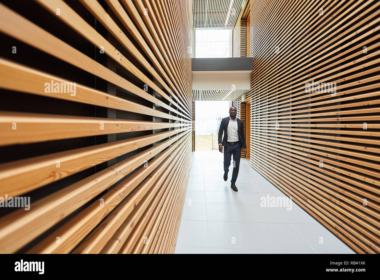 Imprenditore è a piedi da un corridoio con il design moderno in un edificio per uffici Foto Stock