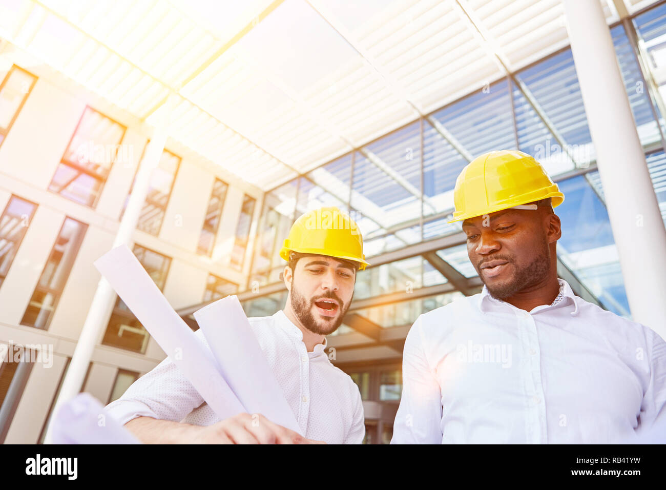 Architetto e costruzione manager alla riunione di pianificazione nella parte anteriore di un ufficio business building Foto Stock