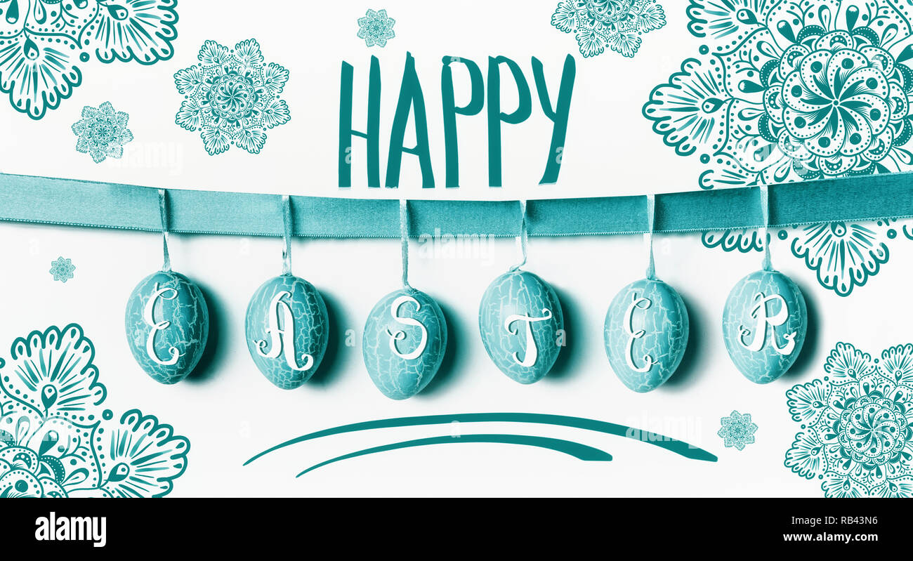 Felice Pasqua biglietto di auguri lettering con appeso turchese uova di Pasqua su nastro con fiori sul muro bianco sullo sfondo Foto Stock