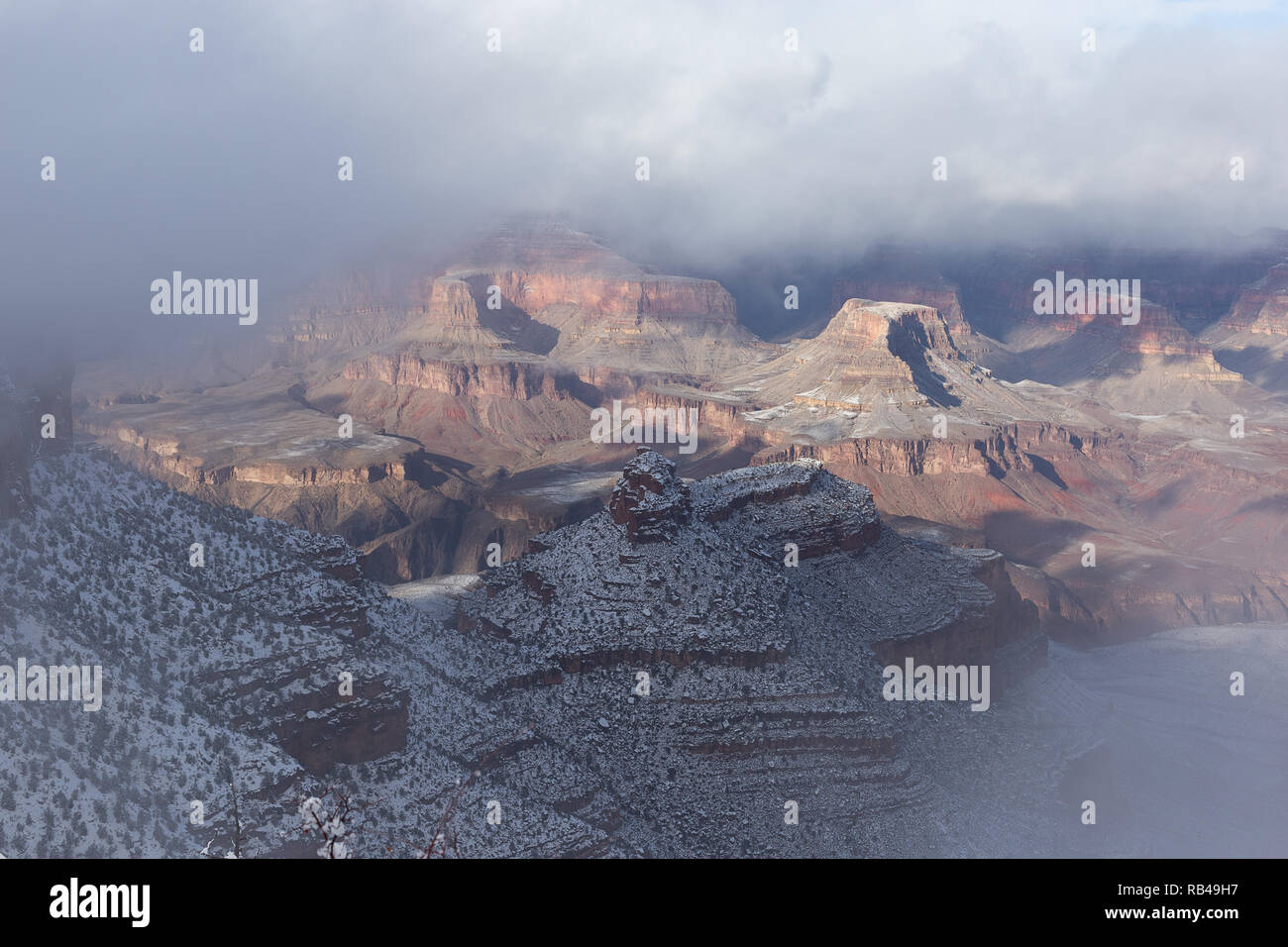 La luce del sole si apre attraverso le nuvole mentre una tempesta invernale della neve inizia a sgombra sul versante sud del Grand Canyon nel Parco Nazionale del Grand Canyon, Arizona, Stati Uniti Foto Stock