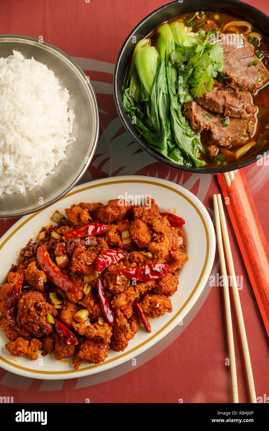 Chong Qing pollo stile con un lato di riso e Taiwan brasato di manzo zuppe sul tavolo di un ristorante cinese Foto Stock