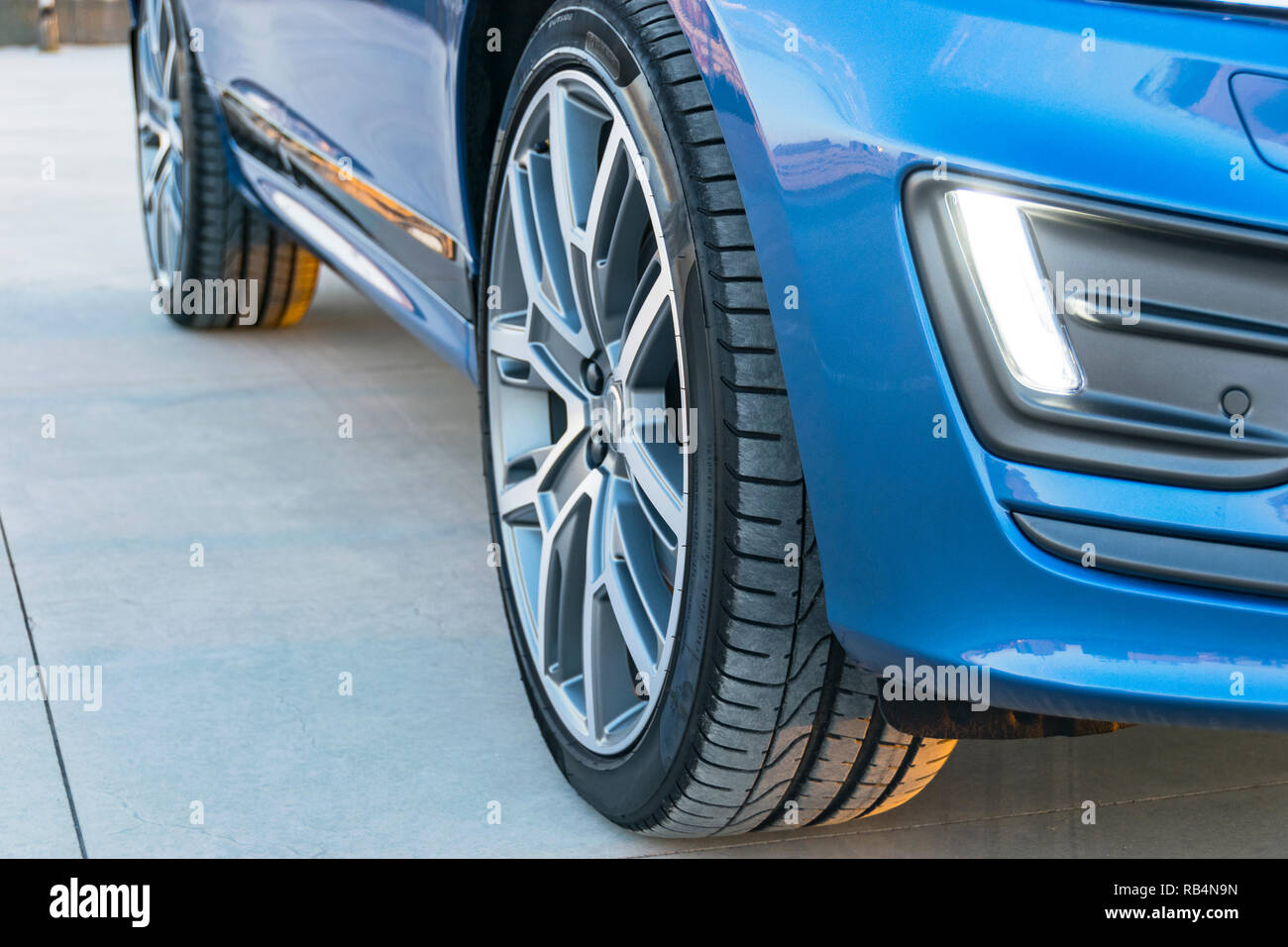 Pneumatico e ruota in lega di una moderna autovettura sul terreno Foto Stock