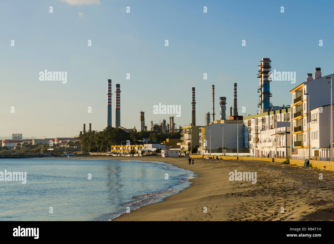 Spiaggia e zona residenziale a San Roque, con Cepsa Algeciras raffineria, dietro, Andalusia, Spagna. Foto Stock