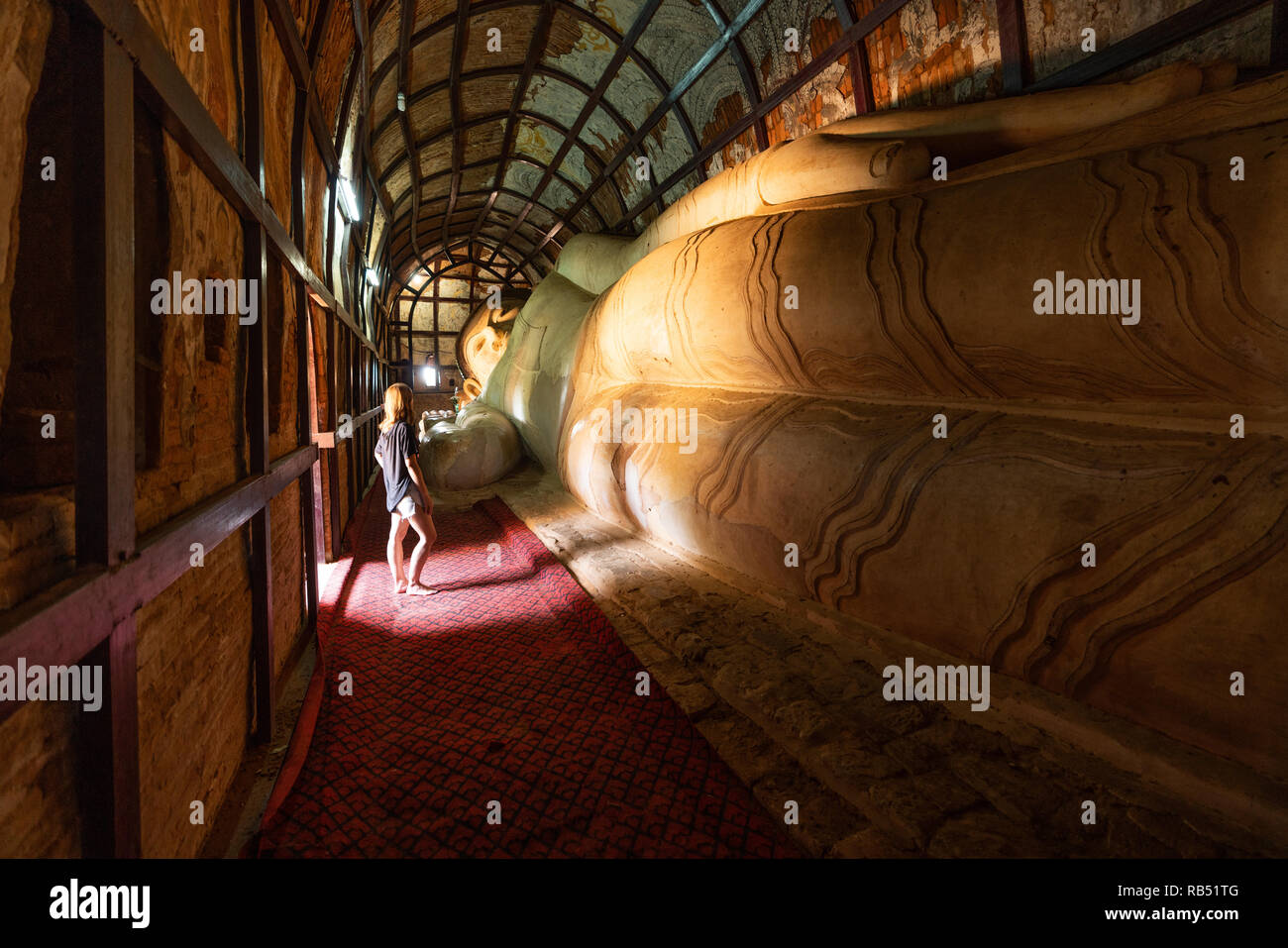 Tourist osservando il Buddha reclinato di Manuha Paya, Bagan, Myanmar Foto Stock