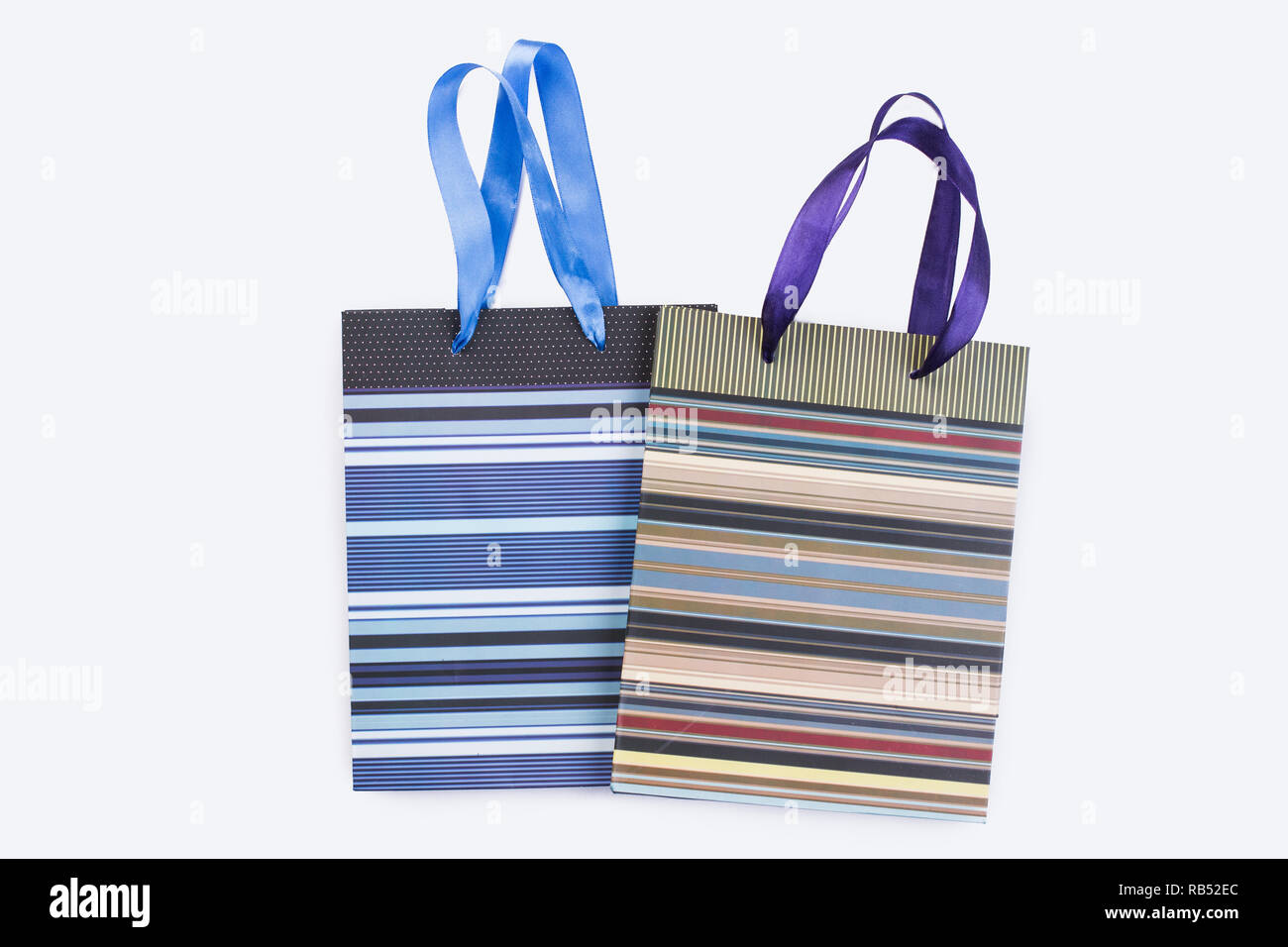 Due fogli di carta shopping bags con manici in raso. Chiudere fino a  strisce Sacchetti regalo su un tavolo di legno. Pacchetti regalo design  Foto stock - Alamy