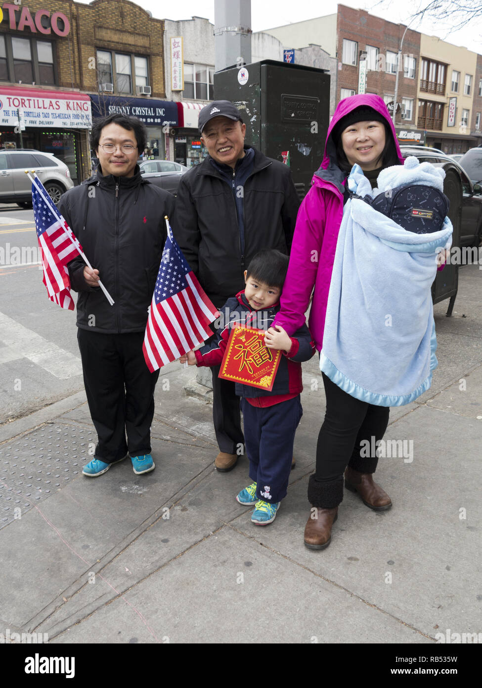 Famiglia cinese frequentare la danza del Leone di cerimonia nella sezione di Bensonhurst di Brooklyn per il Capodanno cinese, 2017. Foto Stock