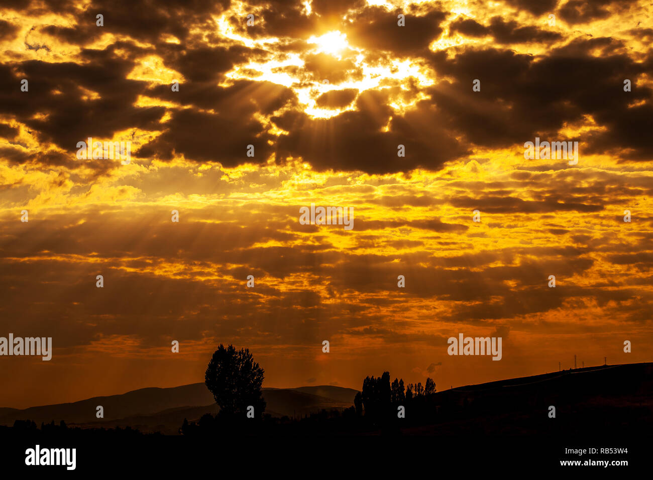 Il sole che splende attraverso basse nubi Foto Stock