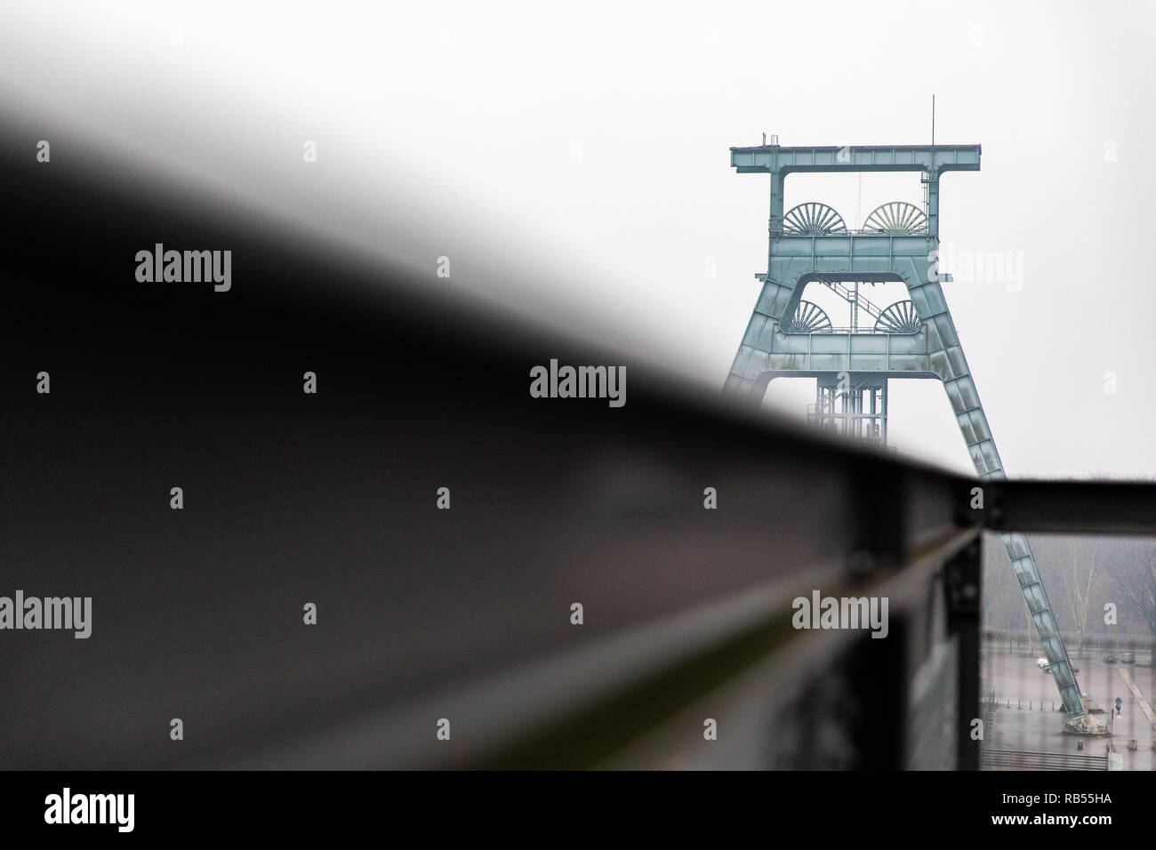 Der Förderturm der Zeche Ewald spiegelt sich in einem Geländer. Foto Stock