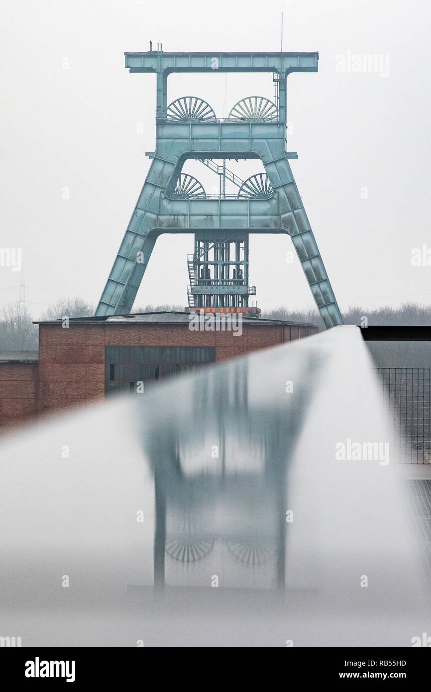 Der Förderturm der Zeche Ewald spiegelt sich in einem Geländer. Foto Stock