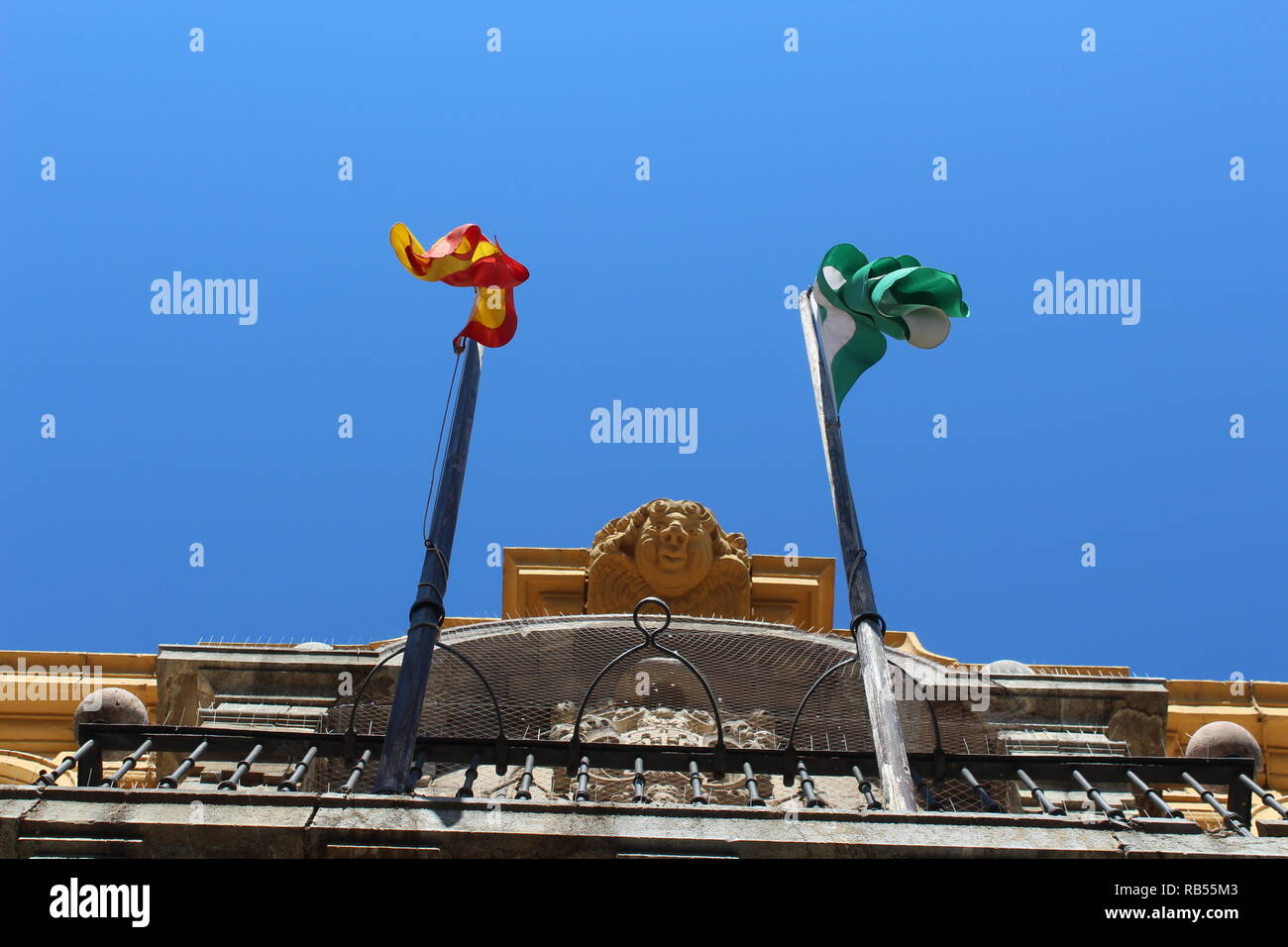 Spagnolo un edificio dallo stile visto da una angolazione inusuale presentando la bandiera spagnola e la bandiera andalusa Foto Stock