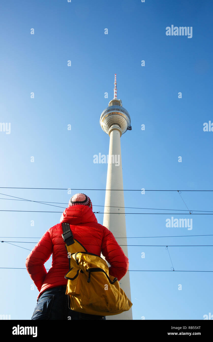 Tourist guardando la monumentale torre della TV, Fernsehturm, dominando il cielo di Berlino, Germania, dal basso. City sightseeing, turismo, monumento, paesaggio urbano. Foto Stock