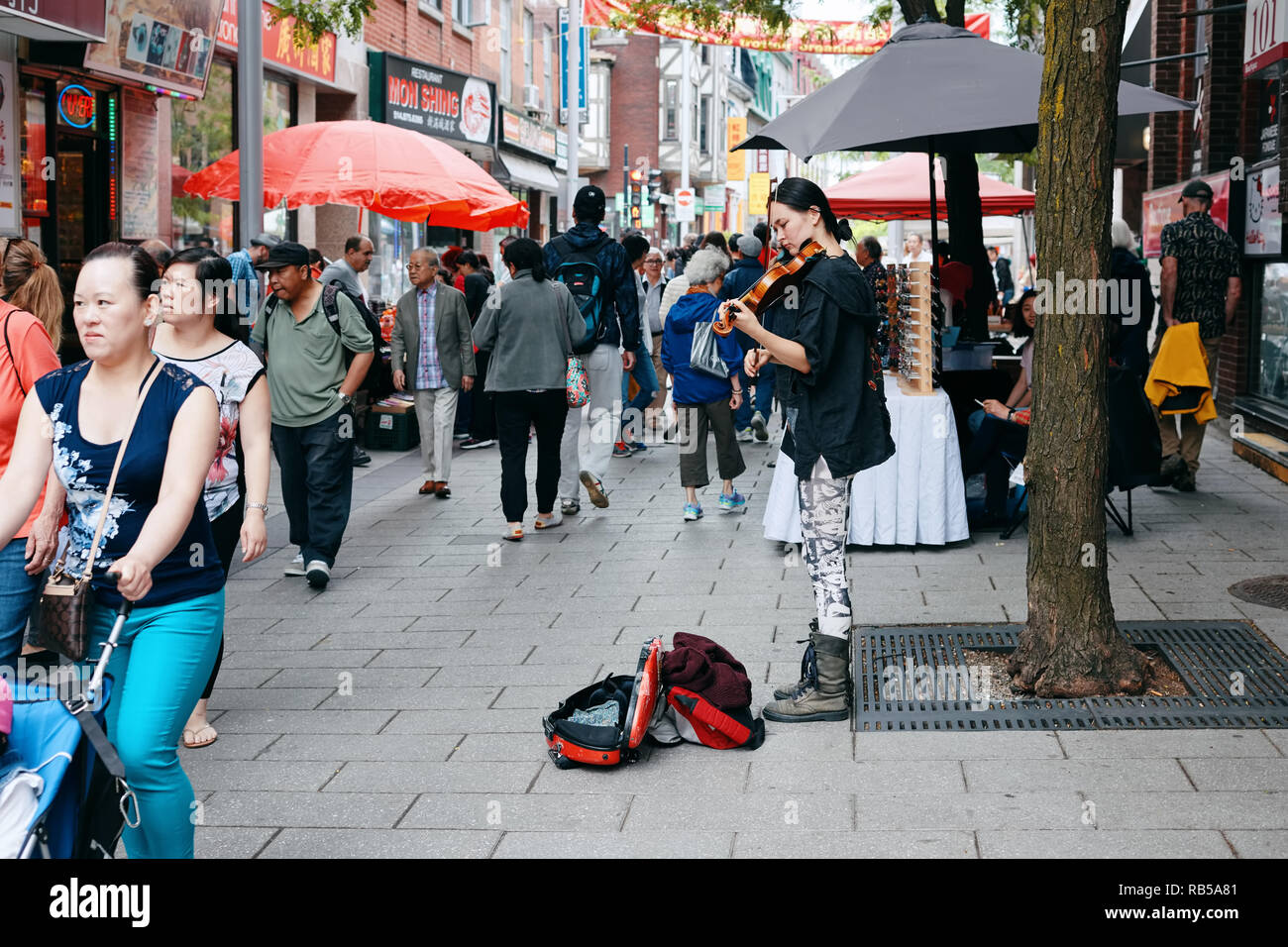 Giovani donne asiatiche musicista di strada suona il violino e il tentativo di raccogliere soldi da persone di passaggio in Chinatown, Montreal, Canada. Foto Stock