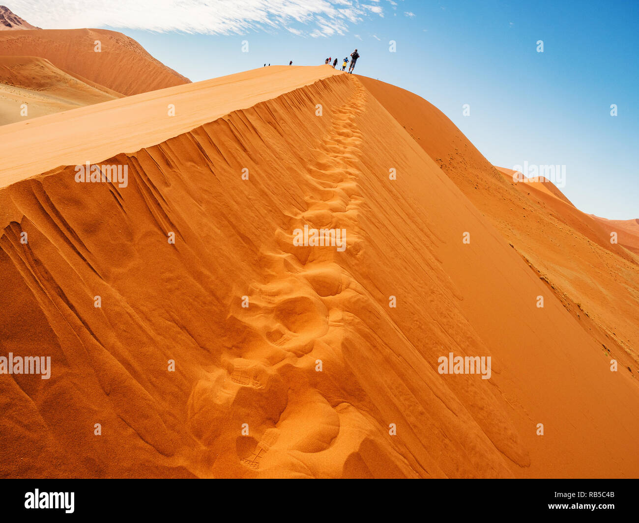 Dune 45 in salina Sossusvlei area del deserto del Namib in Namibia. La gente alla sommità della duna nel bacino di sale del Sossusvlei. Foto Stock