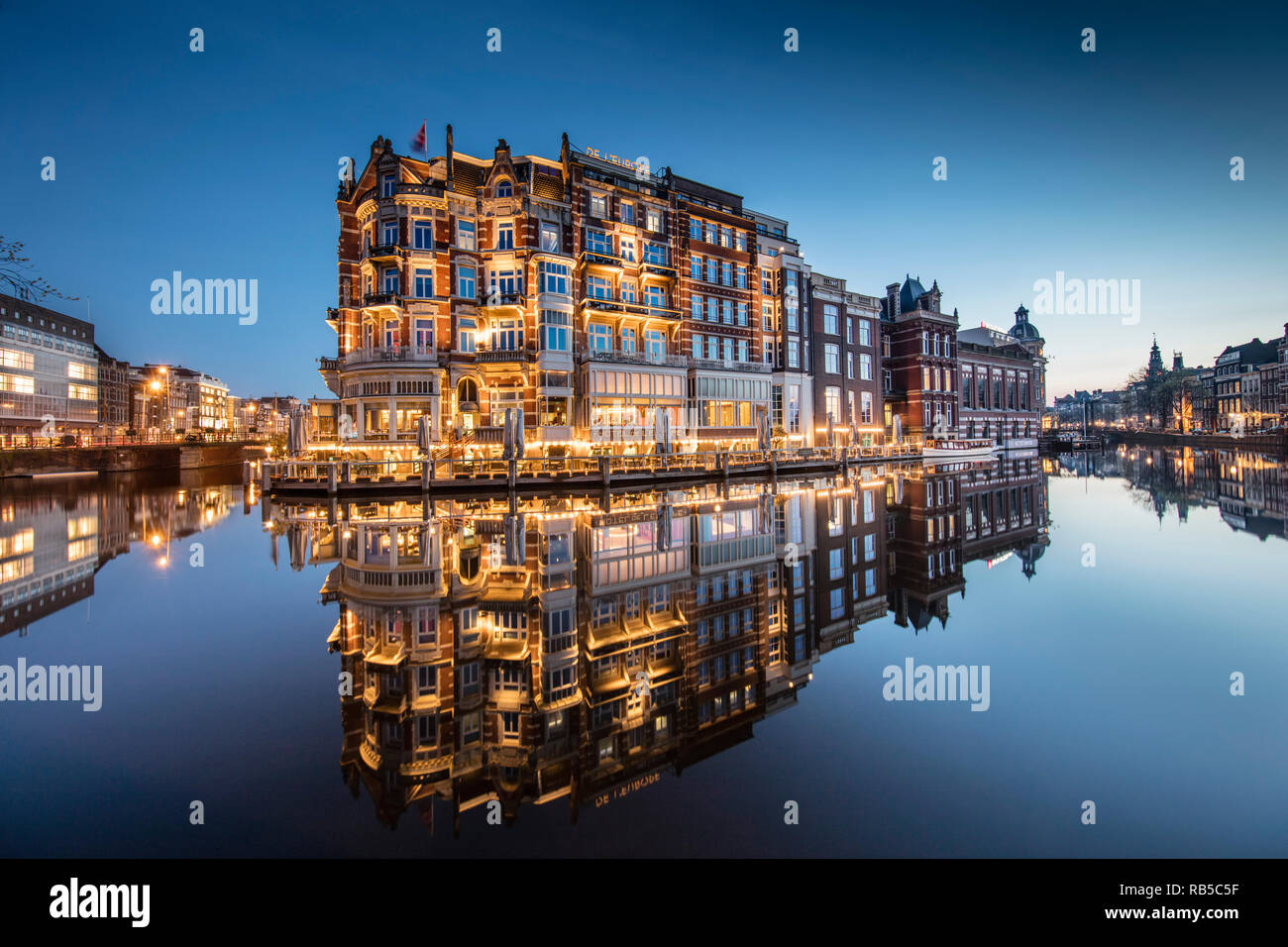 I Paesi Bassi, Amsterdam, Hotel De L'Europe lungo il fiume Amstel. All'alba. Foto Stock