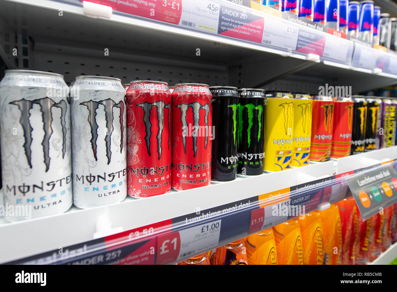 Le lattine di Monster Energy Drink in vendita su un ripiano in un supermercato nel Regno Unito. Foto Stock