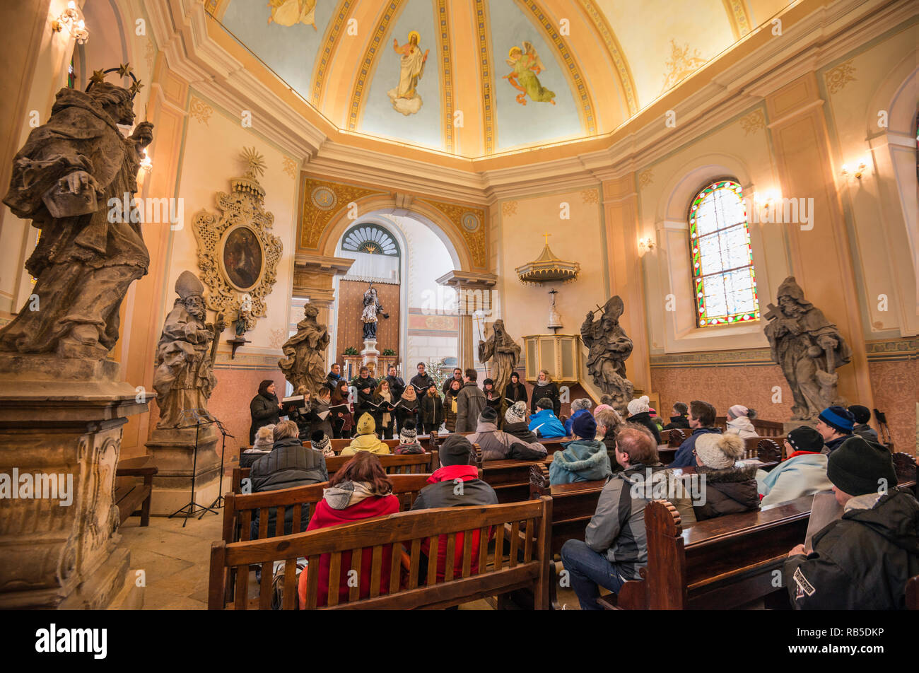 Piccolo Coro eseguendo canti religiosi in stagione di Natale alla chiesa, Valdštejn le rovine del castello di Český ráj (Paradiso Boemo) area, Repubblica Ceca Foto Stock