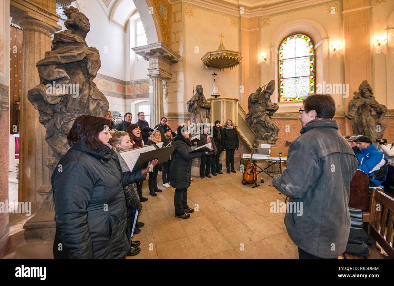 Piccolo Coro eseguendo canti religiosi in stagione di Natale alla chiesa, Valdštejn le rovine del castello di Český ráj (Paradiso Boemo) area, Repubblica Ceca Foto Stock