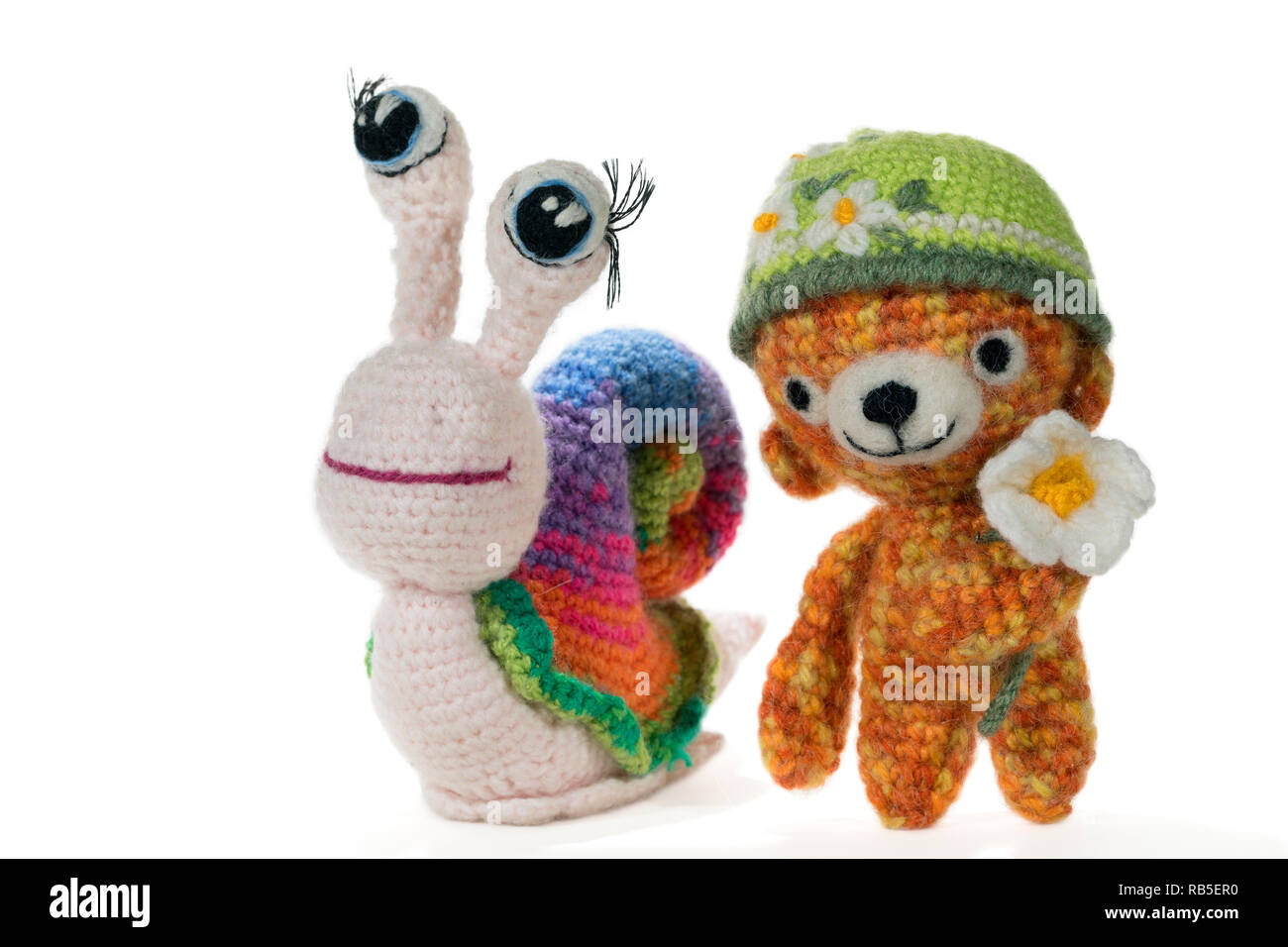 Crochet lumaca arcobaleno con gli occhi e portano a crochet indossando un  cappello con un fiore, su sfondo bianco. Amigurumi. Fatte a mano Foto stock  - Alamy