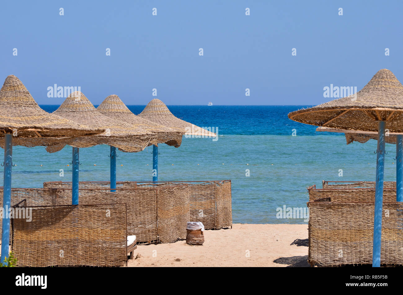 Ombrelloni in spiaggia egiziana con mare blu nel sfondo Foto Stock