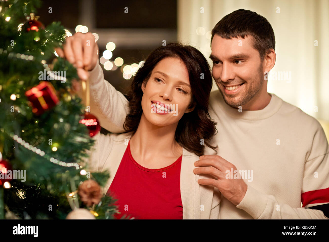 Coppia felice decorazione albero di Natale a casa Foto Stock
