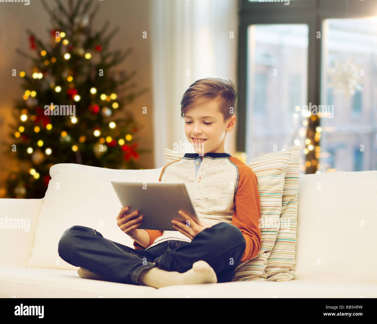 Ragazzo con computer tablet sul Natale a casa Foto Stock
