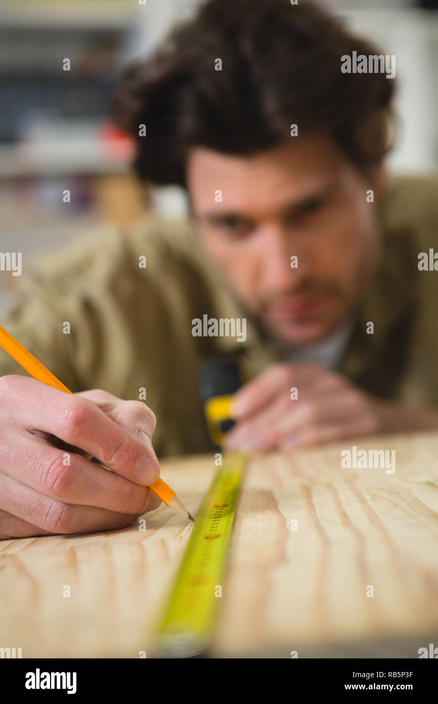 Falegname maschio misura e legno di marcatura Foto Stock