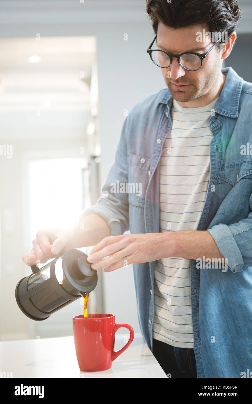 L'uomo versando il caffè dalla stampa francese in tazza Foto Stock