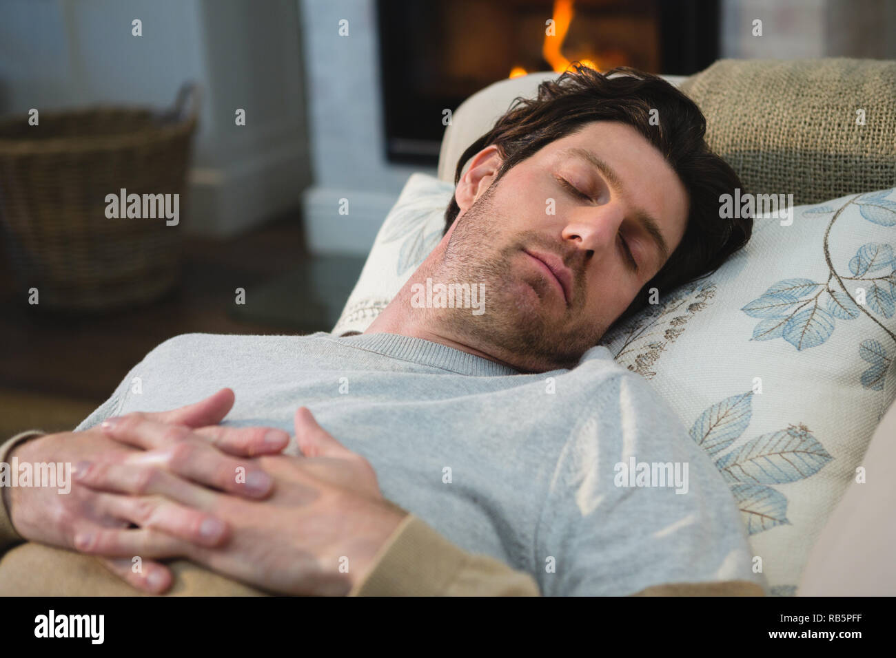 Uomo che dorme sul divano nel soggiorno Foto Stock