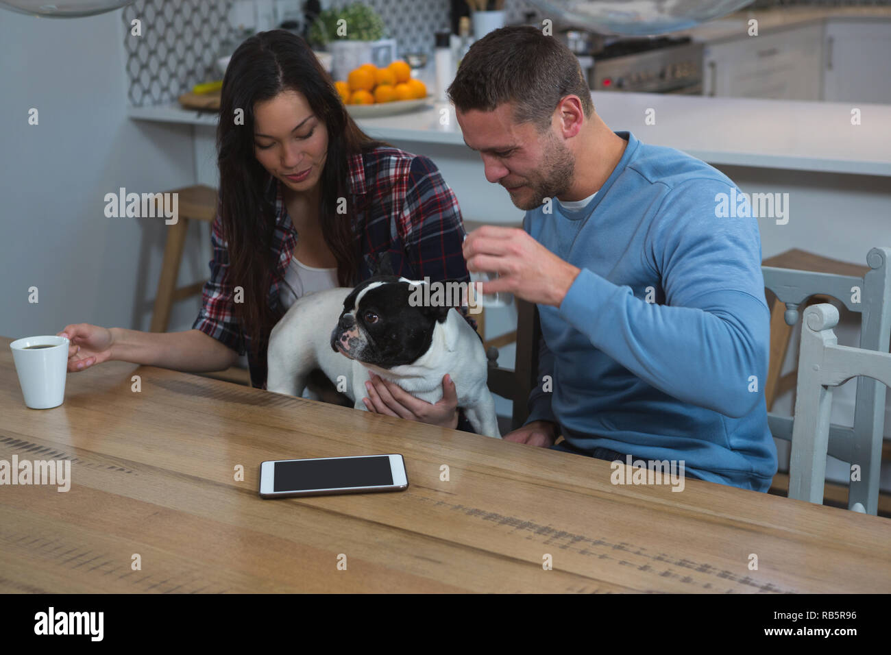 Giovane avente il caffè con il loro cane a casa Foto Stock