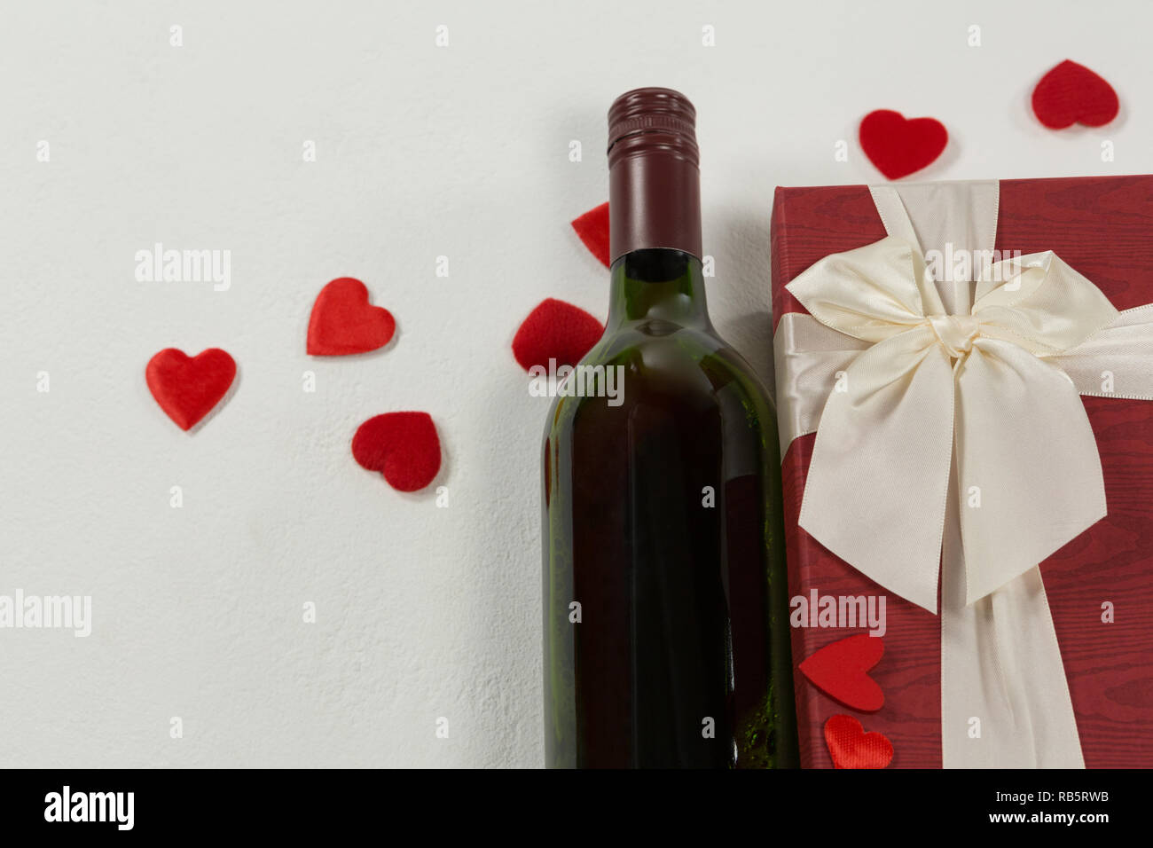 Bottiglia di vino con il regalo di San Valentino e la decorazione su sfondo bianco Foto Stock
