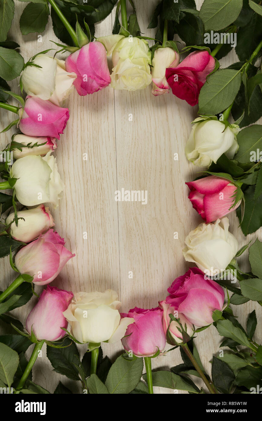 Rose fiori disposti su un tavolo di legno Foto Stock