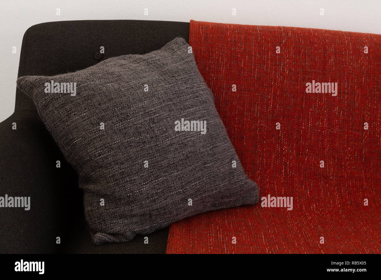 Cuscino e coperta disposto sul divano Foto Stock