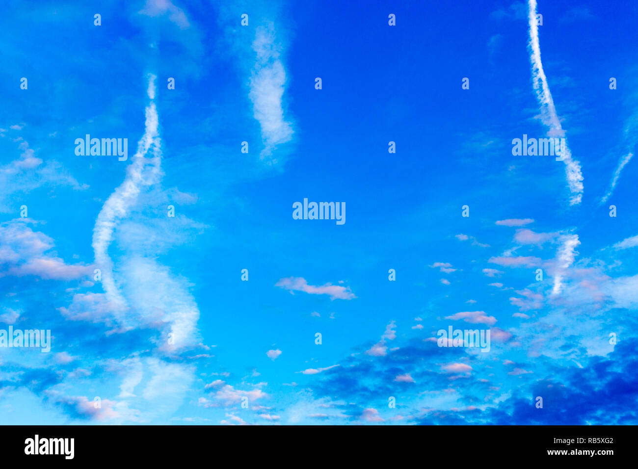 Modello di colore blu scuro, rosa e bianco delle nuvole, aereo sentieri sul cielo blu Foto Stock