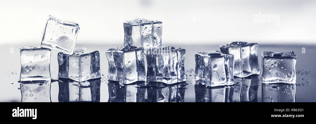 Wet cubetti di ghiaccio sulla superficie nera con riflessione. banner Foto Stock