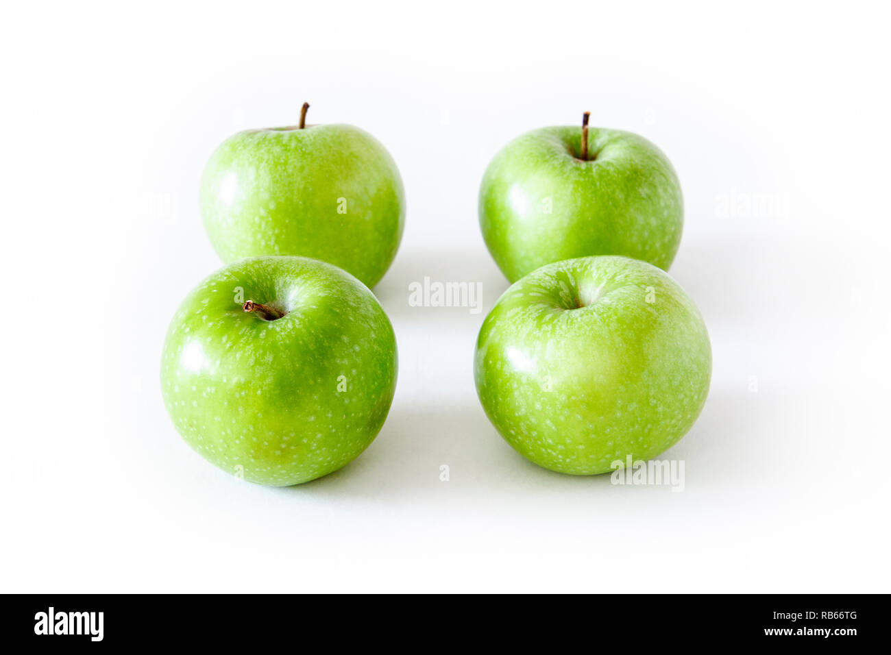 Un gruppo di quattro green le mele Granny Smith isolato su uno sfondo bianco Foto Stock