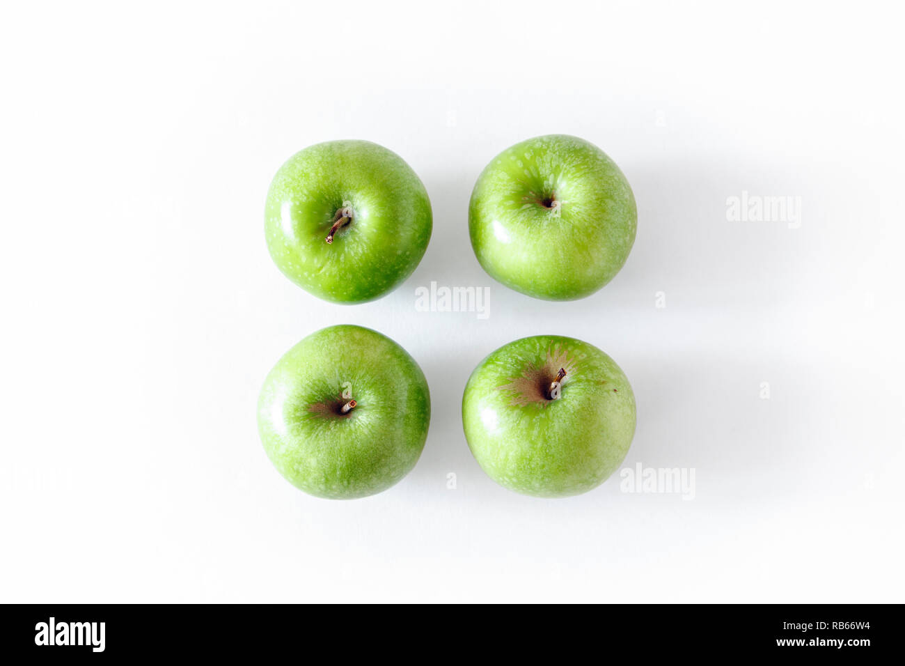 Un gruppo di quattro green le mele Granny Smith isolato su uno sfondo bianco Foto Stock
