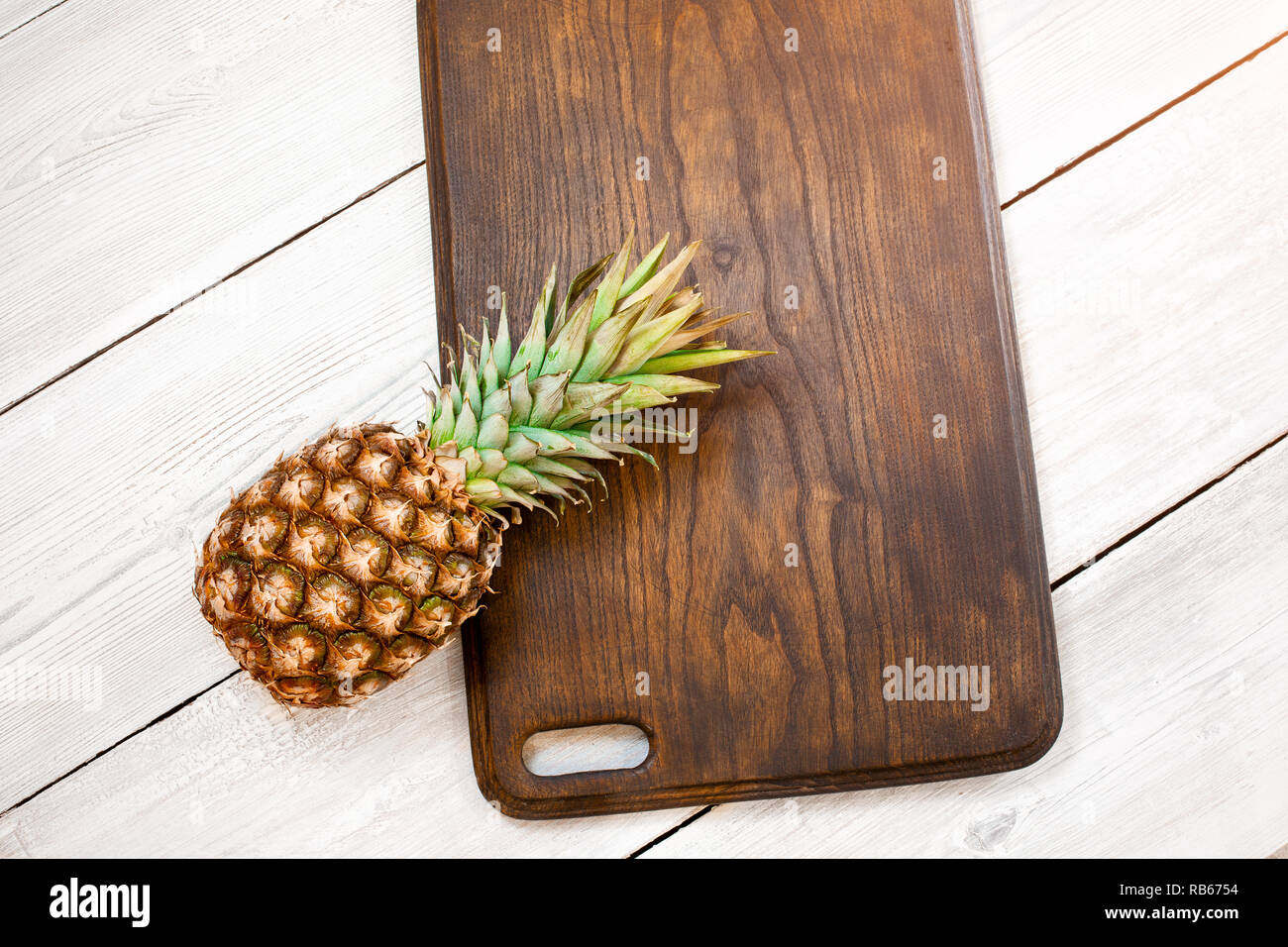 Fresco di ananas maturo su un bianco sullo sfondo di legno, vista dall'alto. Da sopra. Centro Foto Stock