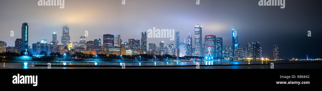 Lunga vista panoramica sullo skyline di Chicago di notte con parte superiore degli edifici coperta di nebbia Foto Stock