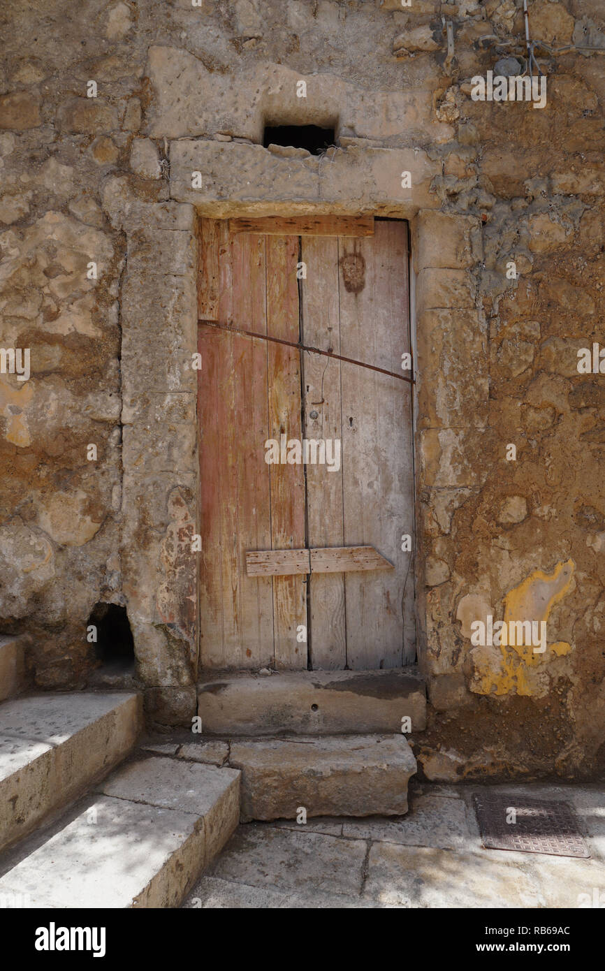 Un antico portale in pietra e porte in legno Foto Stock