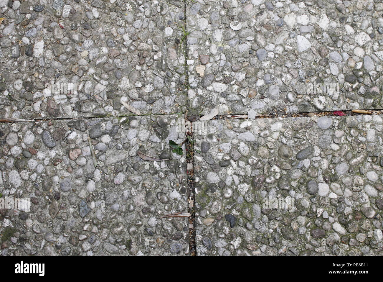 Ciottoli piastrelle per pavimento in background senza giunture. Cemento misto ghiaia di pavimento in pietra texture. Wet round ciottoli rock piano di illuminazione drammatica Foto Stock