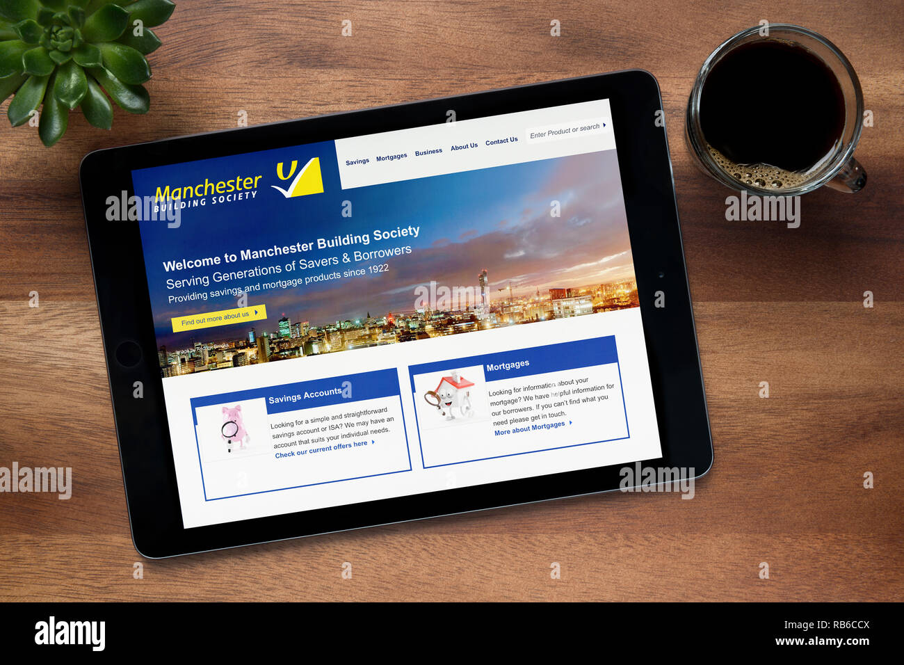 Il sito web di Manchester Building Society è visto su un tablet iPad appoggiato su un tavolo di legno (solo uso editoriale). Foto Stock