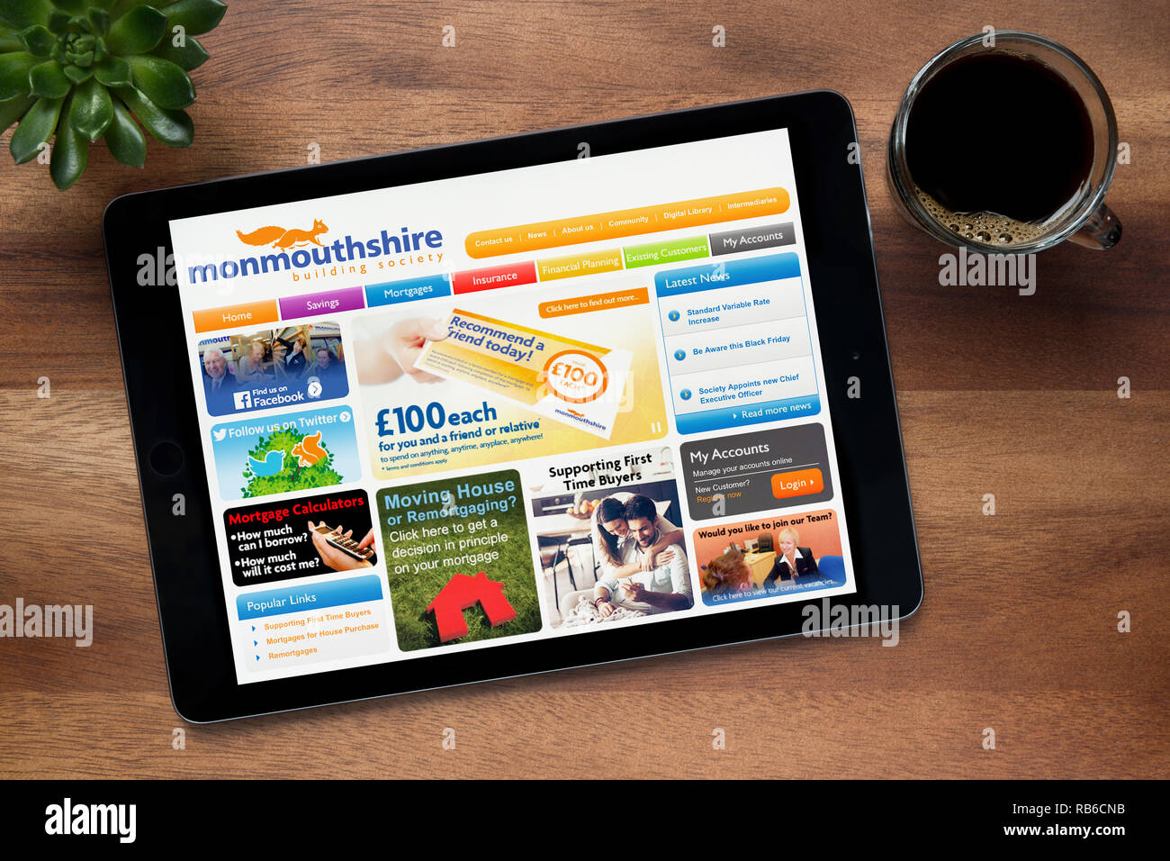 Il sito web di Monmouthshire Building Society è visto su un tablet iPad appoggiato su un tavolo di legno (solo uso editoriale). Foto Stock