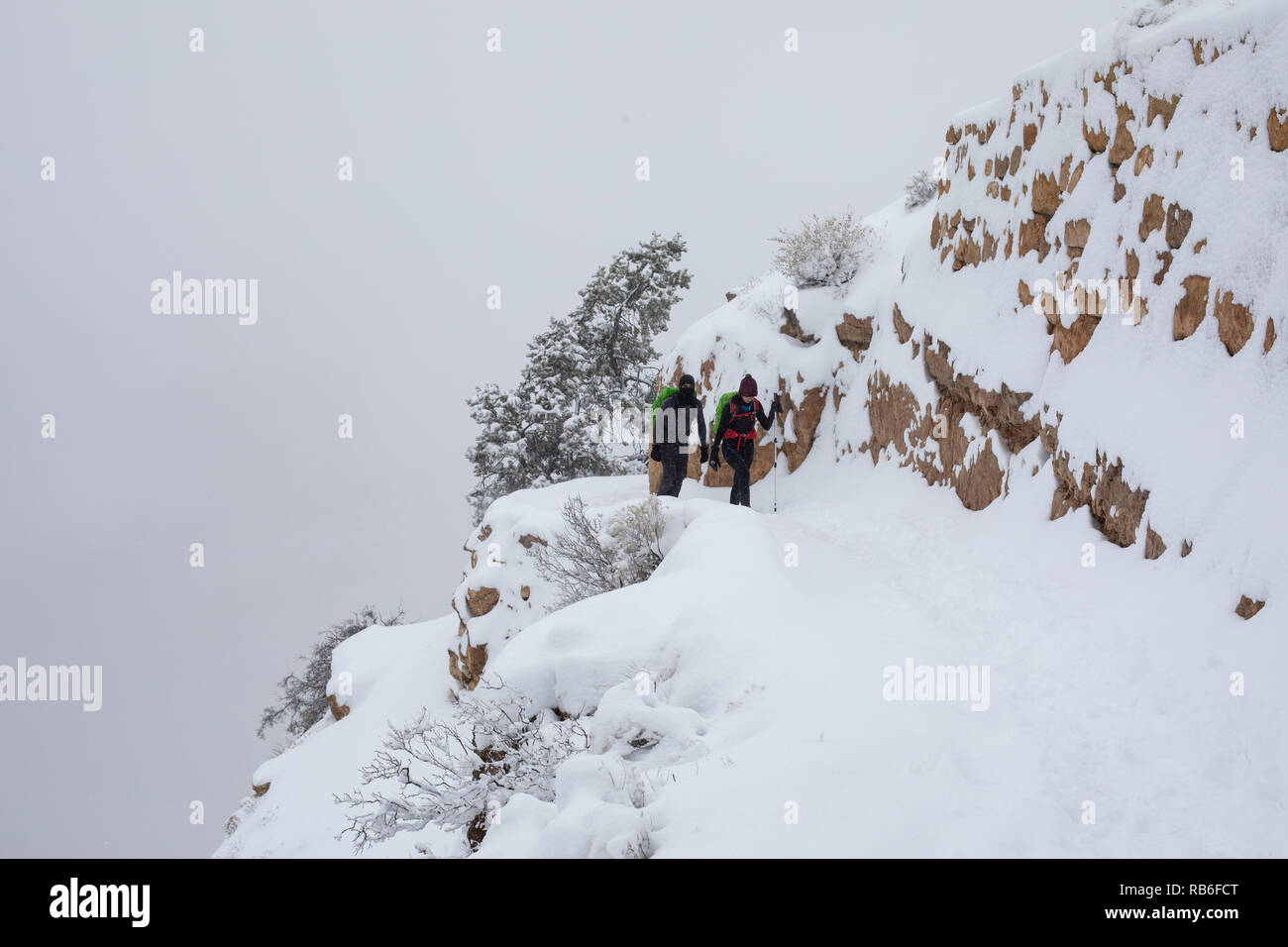 Un paio di escursionisti camminano attraverso la neve sul Bright Angel Trail nel Parco Nazionale del Grand Canyon, Arizona, USA Foto Stock