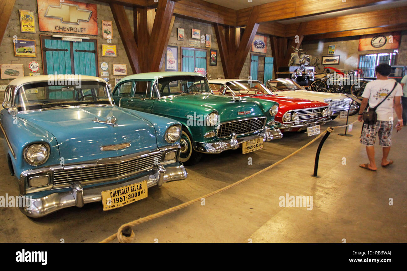 Un visitatore visto accanto ad una collezione di Chevrolet Bel Air (1957) presso il Museo Angkut (Museo dei Trasporti). Questo museo ha migliaia di collezioni di veicoli di varie epoche. Foto Stock