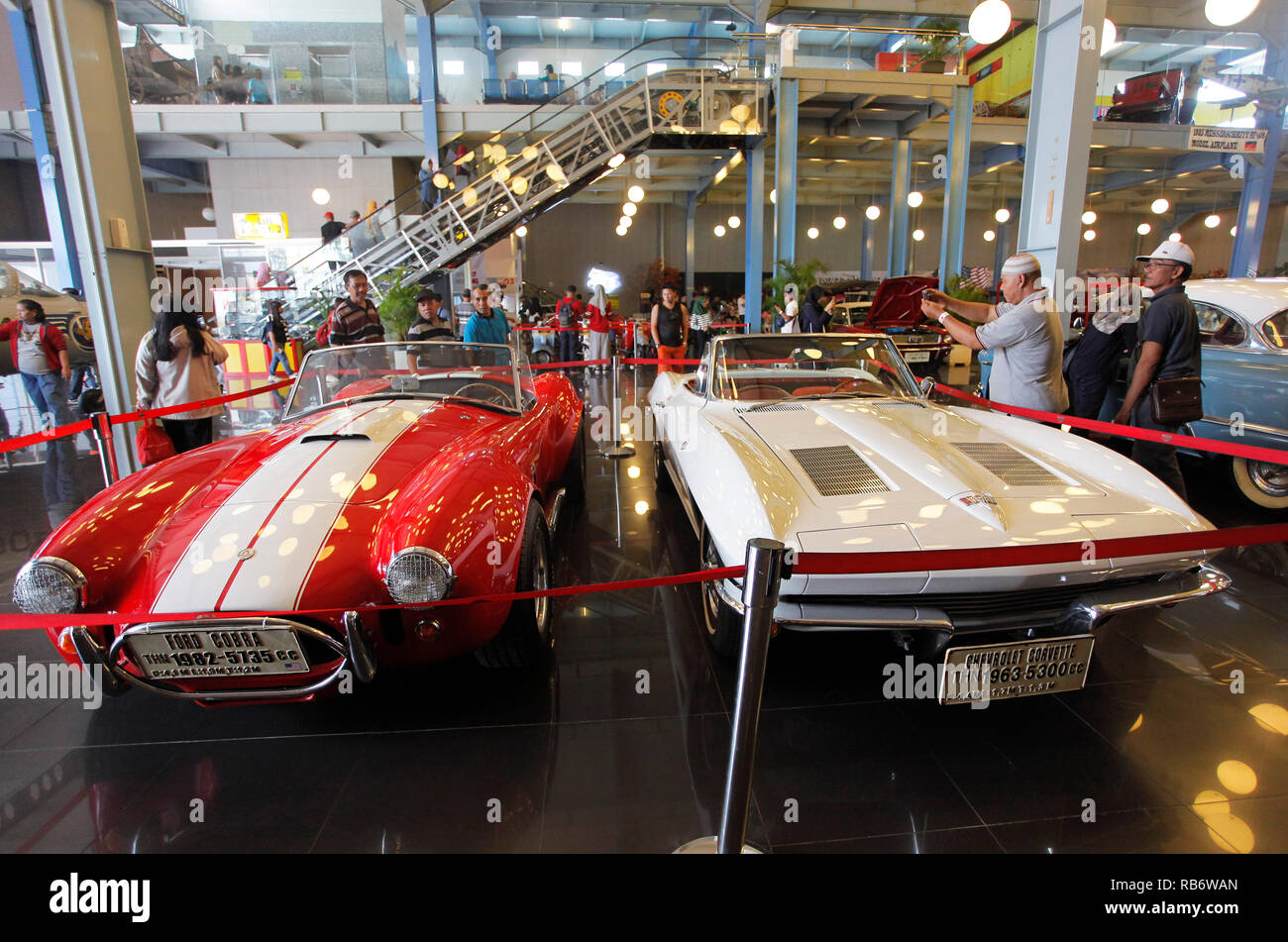 Il vecchio Ford Cobra (1982) e la Chevrolet Corvette (1963) Le autovetture provenienti dal Museo Angkut (Museo dei Trasporti) con gli smartphone. Questo museo ha migliaia di collezioni di veicoli di varie epoche. Foto Stock
